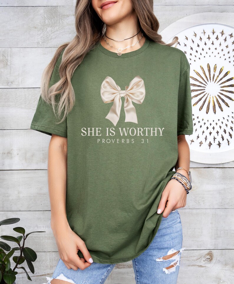 May include: A green t-shirt with a white bow and the text "She is worthy Proverbs 31" printed on the front.