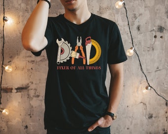 May include: Black t-shirt with a graphic of tools forming the word "DAD" and the text "Fixer of all things".
