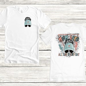 K&ouml;nnte beinhalten: Zwei wei&szlig;e T-Shirts mit einem grafischen Design einer Frau, die eine blaue Baseballkappe mit einem unordentlichen Dutt und Sonnenbrille tr&auml;gt. Das Design auf der R&uuml;ckseite des Shirts lautet "Mom Life All Day Every Day" mit einem Leopardenmuster im Hintergrund.
