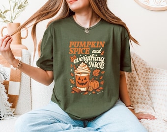 May include: Olive green t-shirt with the text "PUMPKIN SPICE and everything NICE" in orange and white. The graphic includes a pumpkin spice latte, pumpkins, and fall leaves. The shirt is a crew neck.