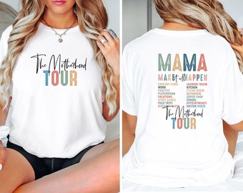 Puede incluir: Camiseta blanca con el texto "The Motherhood Tour" en letras de colores en la parte delantera y "MAMA MAKE it all HAPPEN" con una lista de actividades en letras de colores en la parte posterior.