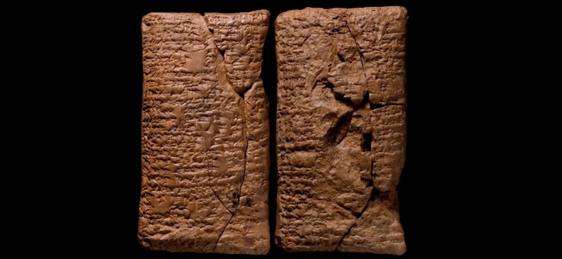 Puede incluir: Dos tablillas de arcilla con escritura cuneiforme, una forma de escritura antigua, inscrita en sus superficies. Las tablillas son marrones y tienen una textura rugosa.