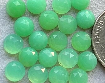 May include: A collection of 18 green gemstone cabochons, each with a faceted surface. The stones are round and have a smooth, polished finish.