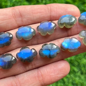May include: Ten iridescent blue labradorite gemstone cabochons carved in a cloud shape.