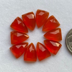 May include: Ten bright orange carnelian gemstone cabochons in a triangular shape, arranged in a circle.