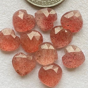 May include: Ten heart-shaped, faceted, pink and clear quartz stones. The stones are approximately 1/2 inch in size.