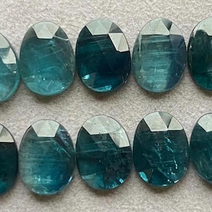 Peut inclure: Dix pierres précieuses ovales bleu turquoise avec une taille facetée. Les pierres précieuses ont une apparence translucide avec des stries internes visibles.