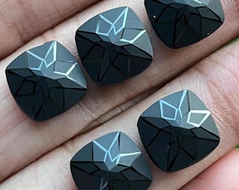 May include: Five black square-shaped gemstones with a star-shaped design carved into the surface.