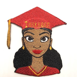 May include: Embroidered patch featuring a woman wearing a red graduation cap with the word "TUSKEGEE" in gold lettering. The woman has brown skin, black hair, and red lipstick. Gold tassel and earrings complete the design.