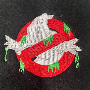 May include: Embroidered patch featuring a white ghost with green slime dripping from it, inside a red circle with a diagonal red line through it. The circle has a black outline.