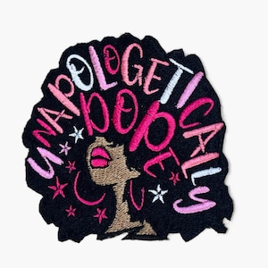 May include: Embroidered patch with a black afro silhouette and the text "Unapologetically dope" in pink and white lettering.
