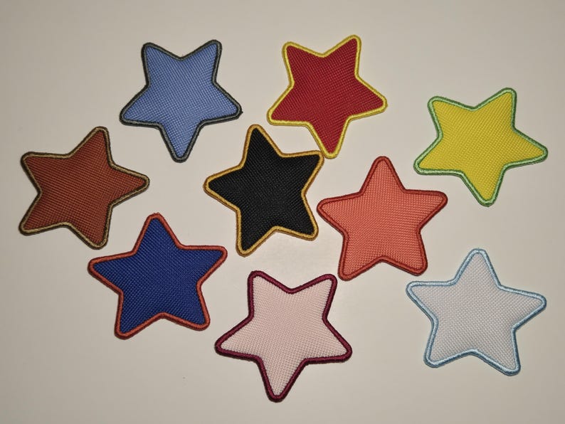 May include: A collection of ten star-shaped patches in various colors, including blue, red, yellow, and black. Each patch has a contrasting border, and a mesh-like texture.