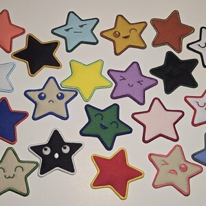 May include: A collection of embroidered star patches in various colors, including red, blue, yellow, and green. Each star features a different facial expression, such as smiling, winking, or frowning. The patches are likely for clothing or accessories.