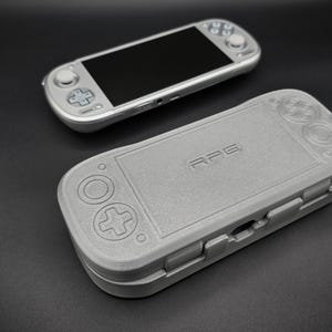 Könnte beinhalten: Ein Set aus drei Keramikbechern mit gesprenkelter, matter Oberfläche. Die Becher sind in den Farbtönen Creme, Hellgrau und Dunkelgrau gehalten. Jeder Becher hat ein schlichtes, minimalistisches Design und einen abgerundeten Henkel.