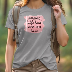 May include: Gray t-shirt with a pink watercolor background and the text "Mom hard Wife hard Work hard Repeat" in a white box.