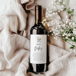 May include: A wine bottle with a label that says "ERSTES Baby" and features a green and blue baby carriage with a star. The label also includes text in German.
