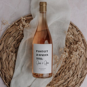 Può includere: Una bottiglia di vino rosato con un'etichetta bianca che recita "Passt gut zum neuen Titel: Oma + Opa" Baby Weller kommt im Juli 2024.