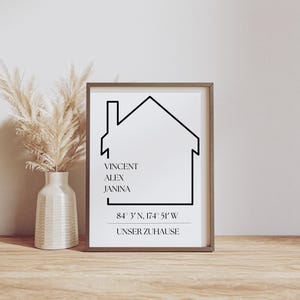 Puede incluir: Una impresión en blanco y negro con un contorno de casa, los nombres Vincent, Alex y Janina, y las coordenadas 84° 3' N, 174° 51' W. El texto "Unser Zuhause" está debajo de las coordenadas.