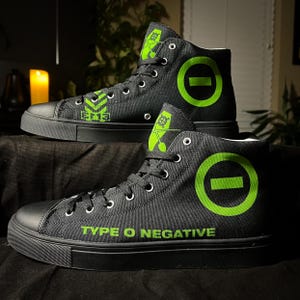 May include: Black high-top canvas shoes with green accents. The shoes feature the band name "TYPE O NEGATIVE" and a green circle with a horizontal line through it.