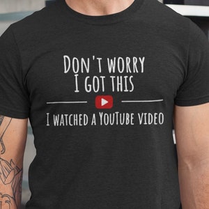 Puede incluir: Una camiseta negra con el texto "Don't worry I got this" y un botón de reproducción de YouTube rojo. El texto debajo del botón dice "I watched a YouTube video".