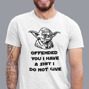 Op de afbeelding: Wit T-shirt met een zwart-witte illustratie van Yoda uit Star Wars. De tekst op het shirt luidt "Offended you I have a shit I do not give."