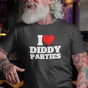 Puede incluir: Una camiseta negra con un gráfico blanco que dice "Me encantan las fiestas de Diddy" con un corazón rojo.