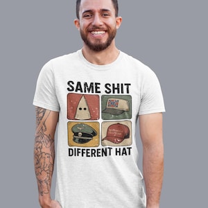 May include: White t-shirt with the text "SAME SHIT DIFFERENT HAT" and four images of hats. The hats include a white hood, a Confederate flag hat, a military hat, and a "Make America Great Again" hat.