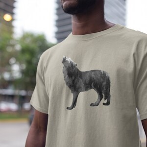May include: A light beige t-shirt with a black and white wolf howling graphic. The wolf is made up of a forest scene.