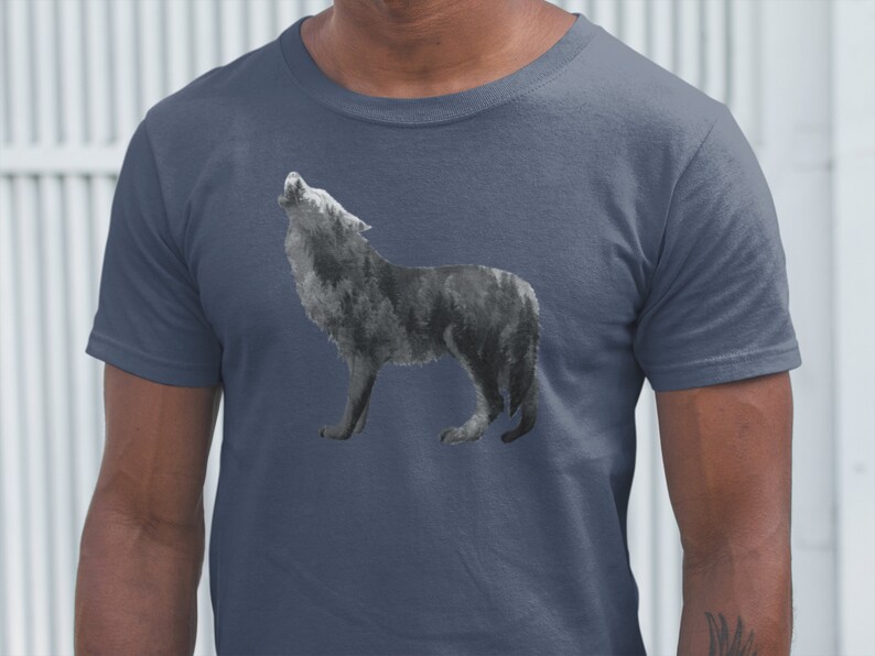 May include: A dark blue t-shirt with a watercolor-style image of a wolf howling at the moon. The wolf is in shades of gray and black.