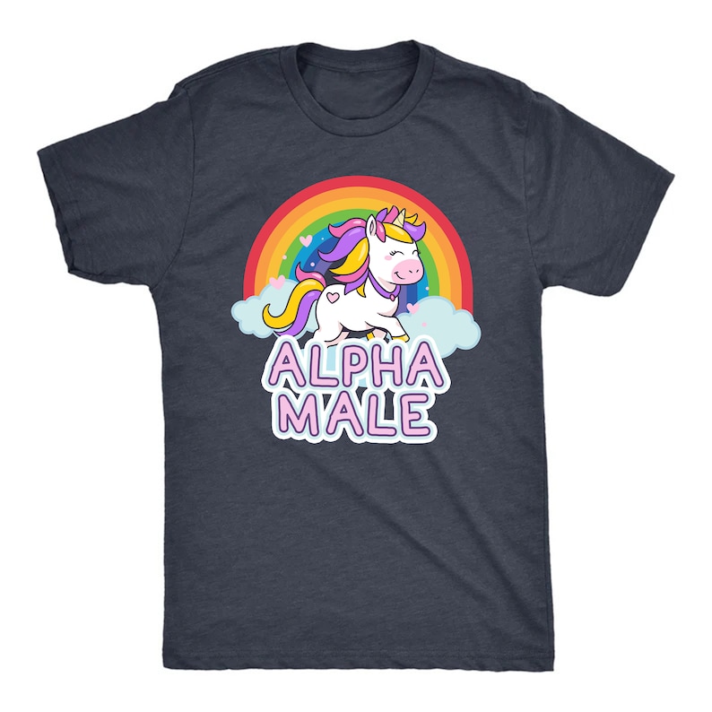 May include: Dark navy blue t-shirt featuring a cartoon unicorn with a rainbow, clouds, and the text "ALPHA MALE" in pink and white. The unicorn has a yellow horn, purple and yellow mane, and a heart on its side.