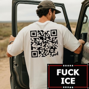 Puede incluir: Camiseta color crema con un gran código QR negro impreso en la espalda. Debajo, un rectángulo negro con las palabras "FUCK ICE" en blanco, con estrellas arriba y abajo.