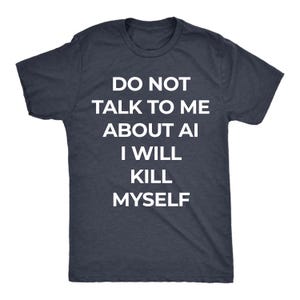 Könnte beinhalten: Ein dunkel anthrazitfarbenes Kurzarm-T-Shirt mit Rundhalsausschnitt und weißem Textaufdruck auf der Vorderseite: DO NOT TALK TO ME ABOUT AI I WILL KILL MYSELF. Das Kleidungsstück hat eine Standardpassform mit geripptem Ausschnitt und kurzen Ärmeln.