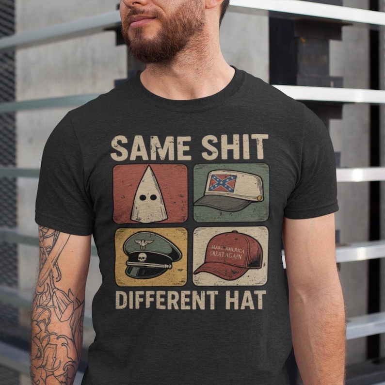 May include: Dark gray t-shirt with the text "SAME SHIT DIFFERENT HAT." The shirt features four images: a white hood, a Confederate flag hat, a military hat, and a red "Make America Great Again" hat.