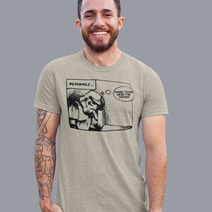 Pu&ograve; includere: Una t-shirt grigia chiaro con una grafica a fumetti in bianco e nero di uno Stormtrooper che dice "Forse erano i droidi". La striscia a fumetti &egrave; intitolata "Nel frattempo..."