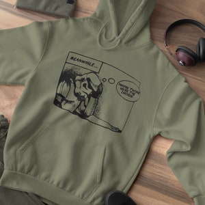 Pu&ograve; includere: Una felpa con cappuccio verde con una grafica a fumetti in bianco e nero che presenta un personaggio con il testo "MEANWHILE... MAYBE THOSE WERE THE Droids".