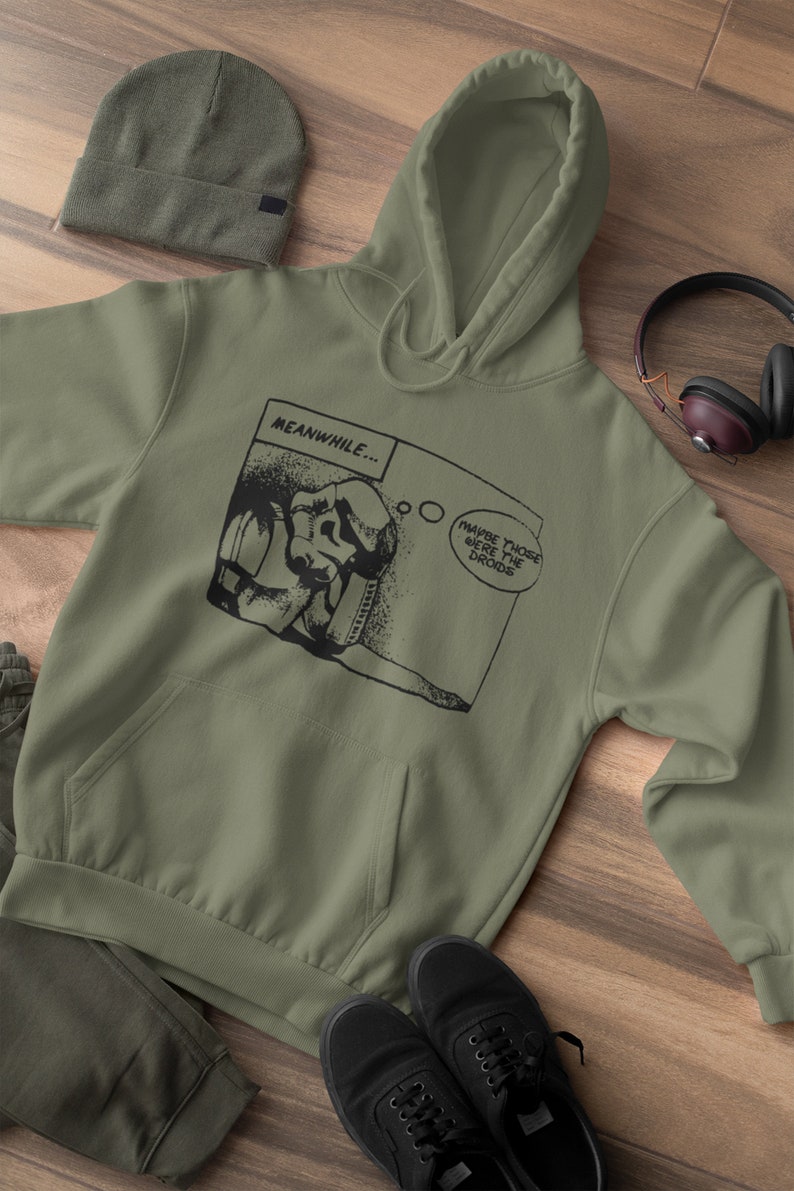Pu&ograve; includere: Una felpa con cappuccio verde con una grafica a fumetti in bianco e nero che presenta un personaggio con il testo "MEANWHILE... MAYBE THOSE WERE THE Droids".