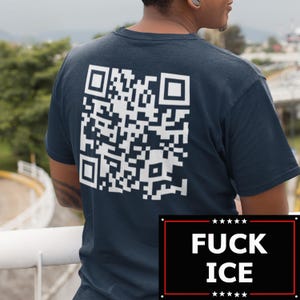 May include: Dark blue t-shirt featuring a large white QR code on the back. Underneath the QR code is a black rectangle with the words "FUCK ICE" in white, with stars above and below the text.