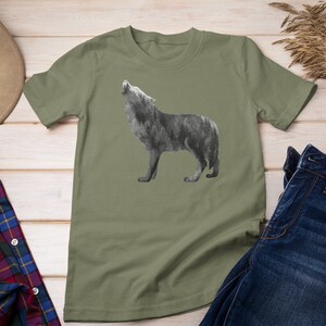 May include: A green t-shirt with a wolf silhouette design. The wolf is howling and is made up of a forest pattern.