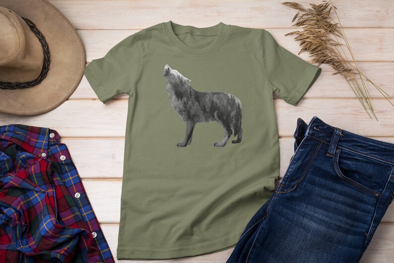 May include: A green t-shirt with a wolf silhouette design. The wolf is howling and is made up of a forest pattern.