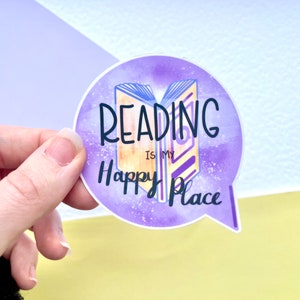 May include: A purple and yellow sticker with a book illustration and the text "Reading is my happy place".