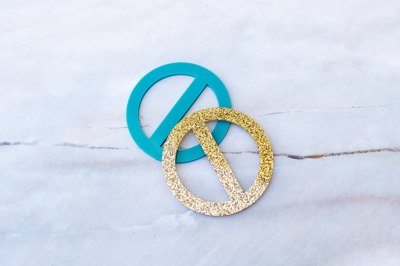 May include: Two decorative circles, one turquoise blue and one gold glitter, with a line across the center of each.