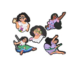 May include: Five colorful shoe charms featuring a cartoon character with dark hair and glasses. The charms depict the character in various poses, wearing different outfits, including a swing and a dress.
