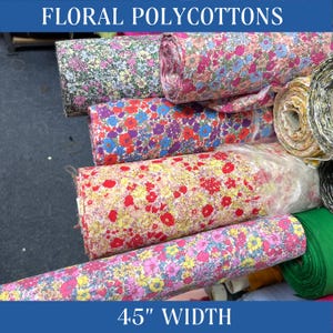 Może przedstawiać: Rolki kolorowych tkanin z kwiatowymi wzorami, każda z innym wzorem. Tkanina ma 4,5 cala szerokości. Floral Polycottons.