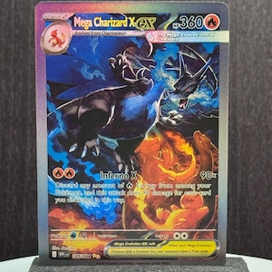 Puede incluir: Una carta coleccionable Pokémon Mega Charizard X EX. La carta presenta una ilustración vibrante de Charizard en tonos azules, negros y naranjas. La carta tiene 360 PS y el texto "Inferno X".