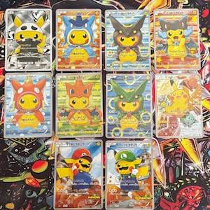 May include: A collection of ten Japanese Pokémon trading cards featuring Pikachu dressed in various costumes, including Mario, Luigi, and different Pokémon-themed outfits, arranged in a grid on a colorful, patterned playmat surface.