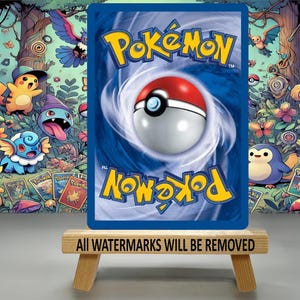 May include: A Pok&eacute;mon trading card with a blue background and the Pok&eacute;mon logo in yellow. The card features a Pok&eacute; Ball design. The card is displayed on a small wooden stand with the text "ALL WATERMARKS WILL BE REMOVED".