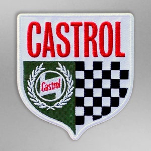 Op de afbeelding: Een wit, geborduurd embleem met het rode woord "CASTROL" bovenaan. Het embleem heeft een groen en wit embleem met het Castrol-logo en een zwart-wit geblokt vlagontwerp.