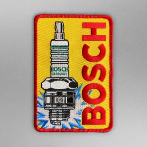 Könnte beinhalten: Ein gestickter Aufnäher in Rot, Gelb und Weiß mit dem Wort "BOSCH" in großen roten Buchstaben und einer Zündkerze mit den Worten "BOSCH GERMANY" darauf.