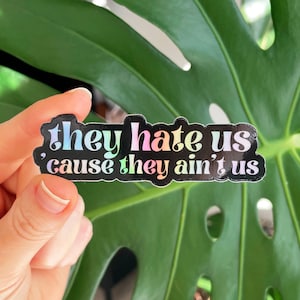 They Hate Us Cause They Ain&#39;t Us, Holographic 3&quot; Vinyl Sticker, UV Water and Scratch Resistant, Water Bottle Sticker, Rainbow Sticker