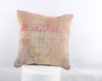 Peut inclure: Un coussin carré avec un fond beige et un motif floral rose et bleu. Le coussin est fait d'un tissu tissé et a un aspect vieilli.